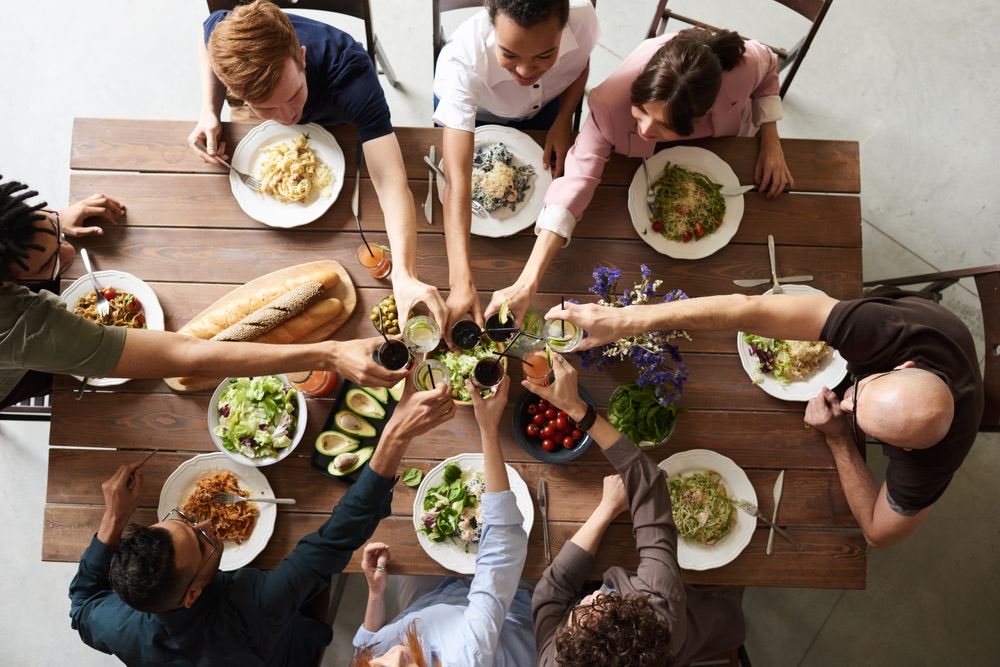 Friends raising glasses around a table
