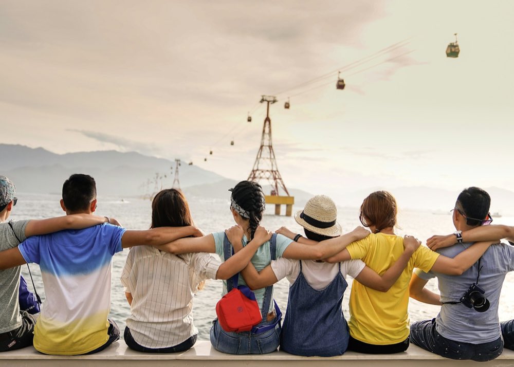 Friends sitting together by the water